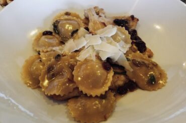 Homemade butternut squash ravioli in a sage butter sauce w/ cranberries and toasted pumpkin seeds